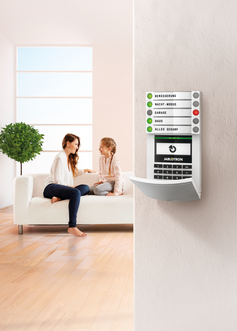 Das Bild zeigt eine Jablotron Alarmzentrale mit einer Familie im Hintergrund.