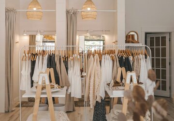 Das Bild zeigt eine Boutique mit ausgehangenen Kleidern.