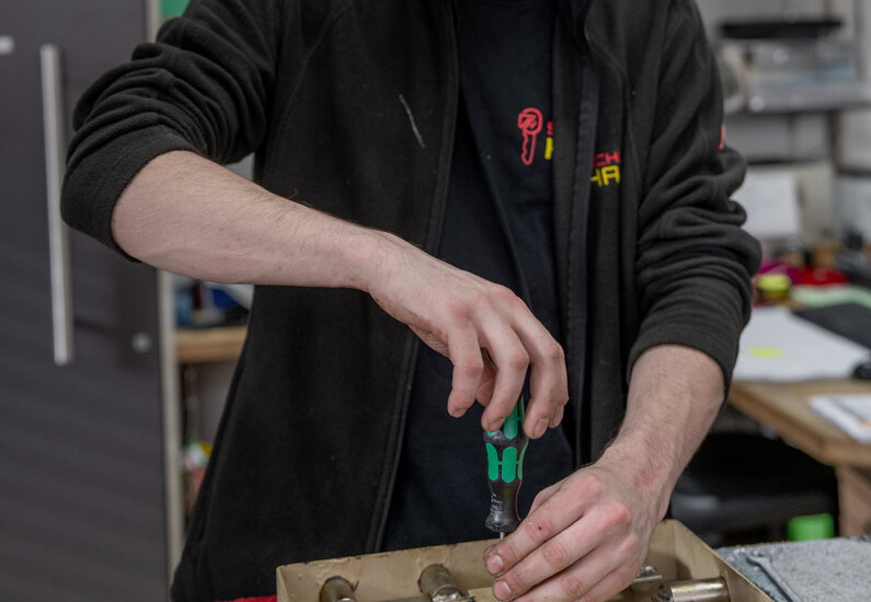 Sicherhaid Das Bild zeigt einen Mitarbeiter bei einer Reparatur eines Tresors.