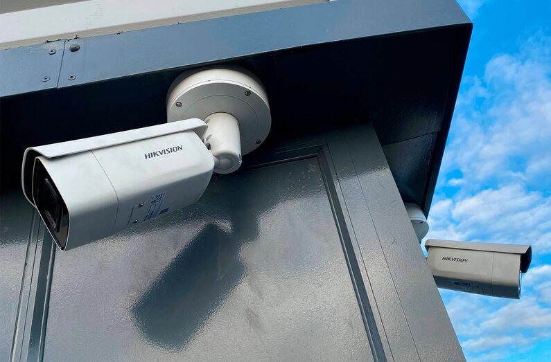 Das Bild zeigt zwei HIKVISION-Kameras im Außenbereich. 