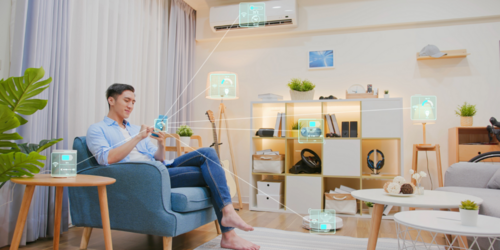 Das Bild zeigt einen modernen Wohnraum mit Smart-Home-Geräten, ein Mann steuert diese per Smartphone.