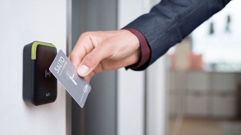 Ein Bild, das die Verwendung einer Zutrittskontrolle bei einer Eingangstüre zeigt.