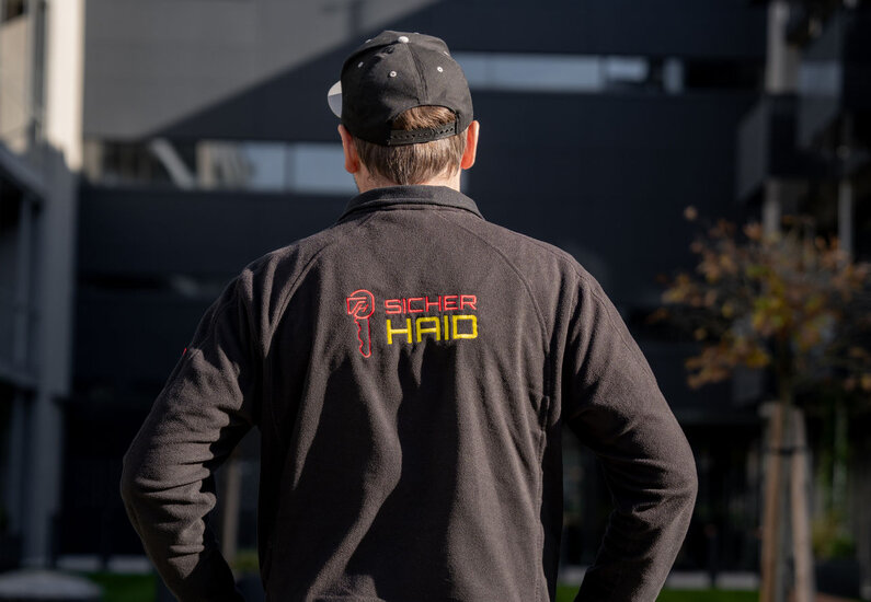Sicherhaid Ein Bild, dass einen Mitarbeiter vor einem Bauprojekt darstellt.