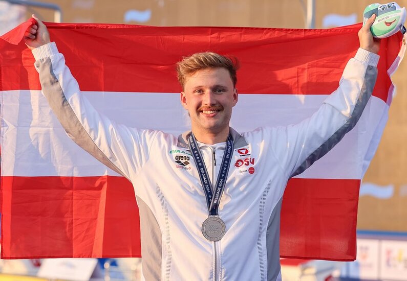 Simon Bucher Ein Foto, das den Schwimmer Simon Bucher beim Halten der österreichischen Nationalfahne zeigt.