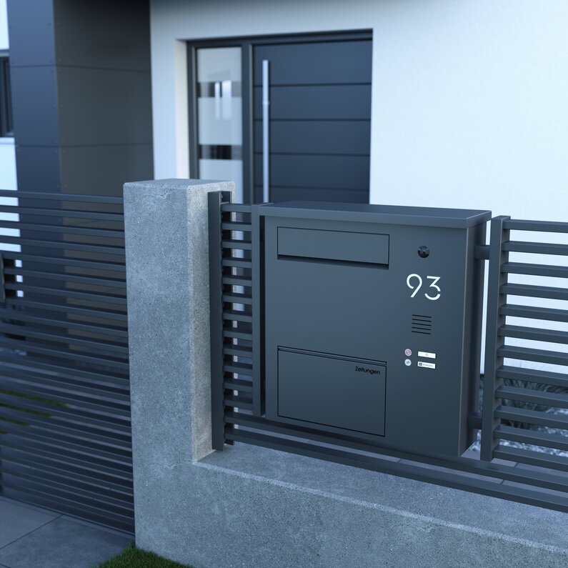 Das Bild zeigt einen Briefkasten, der in einem Zaun verbaut ist.