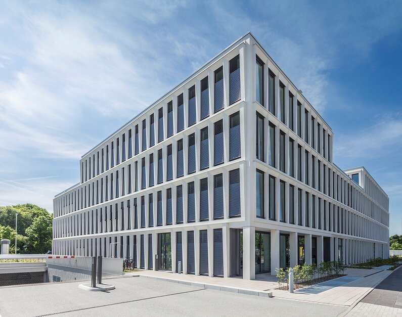 Das Bild zeigt ein modernes Bürogebäude von Außen. 